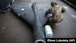 Украинский военный осматривает сбитый российский беспилотник типа "Шахед" с термобарическим зарядом, ноябрь 2024 года